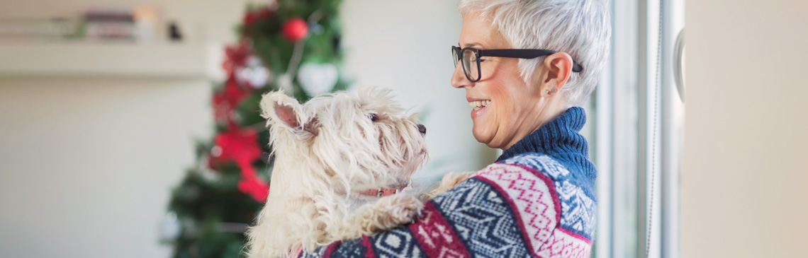 lady looking at her dog side view with holiday background