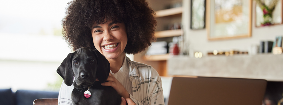 woman holding black puppy